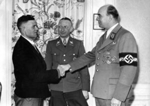 Gaulieter Arthur Greiser und SS-Brigadeführer Heinz Reinfarth bei der Begrüßung eines Umsiedlers aus Schwarmeer-Raum. Jahr 1944.